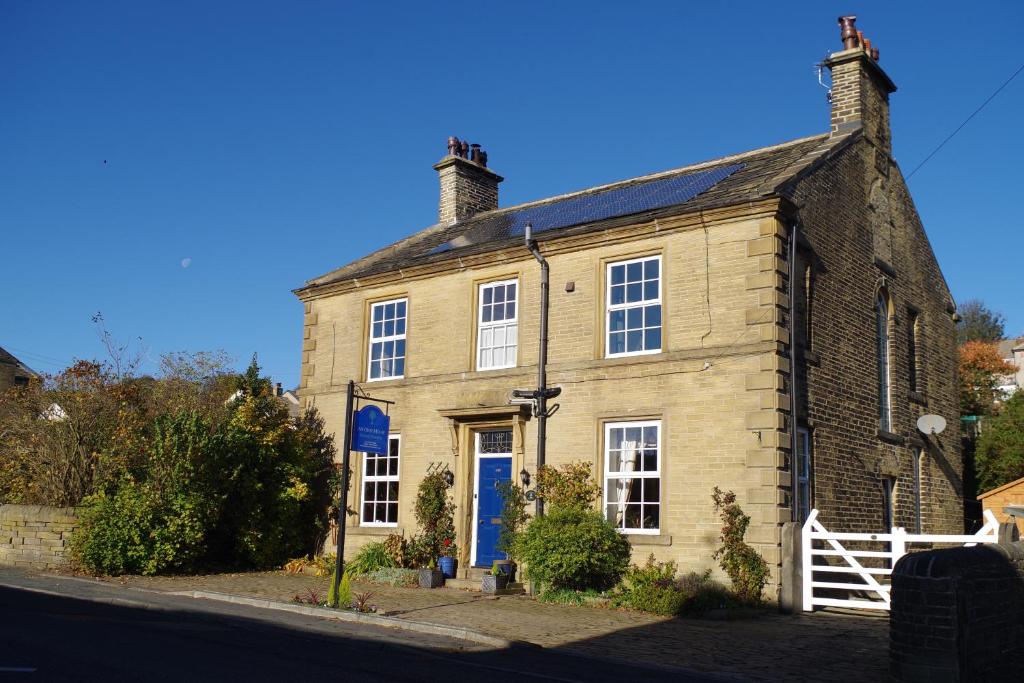 an old brick house with a blue door on a street at Ashtree House Bed and Breakfast in Thornton