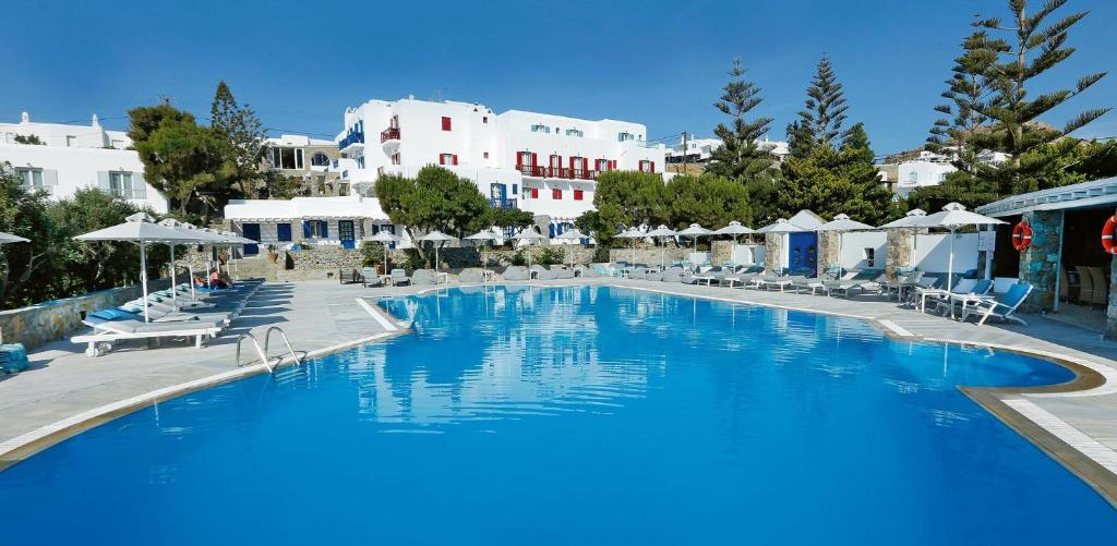 een groot zwembad met witte gebouwen op de achtergrond bij Kamari Hotel in Platis Yialos Mykonos