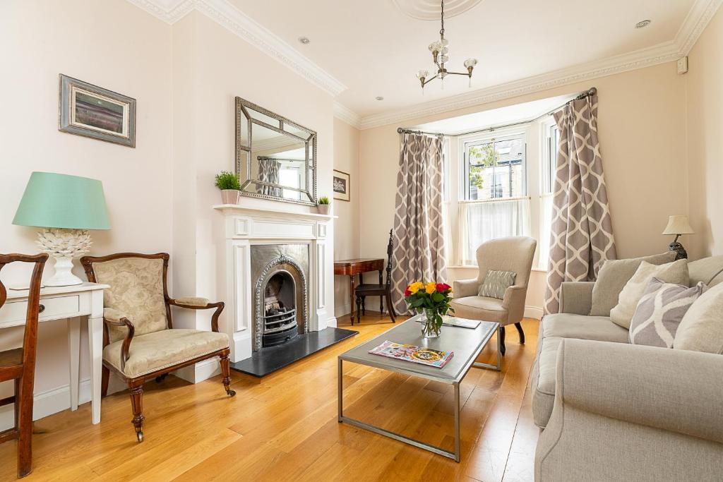 uma sala de estar com um sofá e uma lareira em JOIVY Stunning 3 bed, 2 bath house with garden and rooftop terrace em Londres
