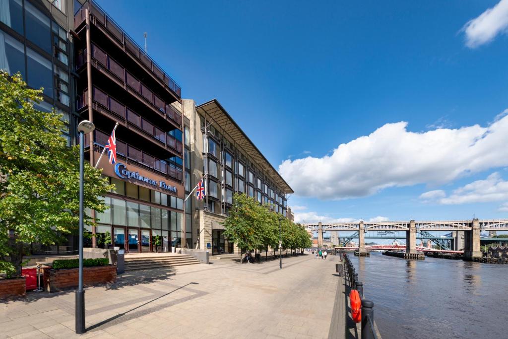 een gebouw naast een rivier met een brug bij Copthorne Hotel Newcastle in Newcastle upon Tyne