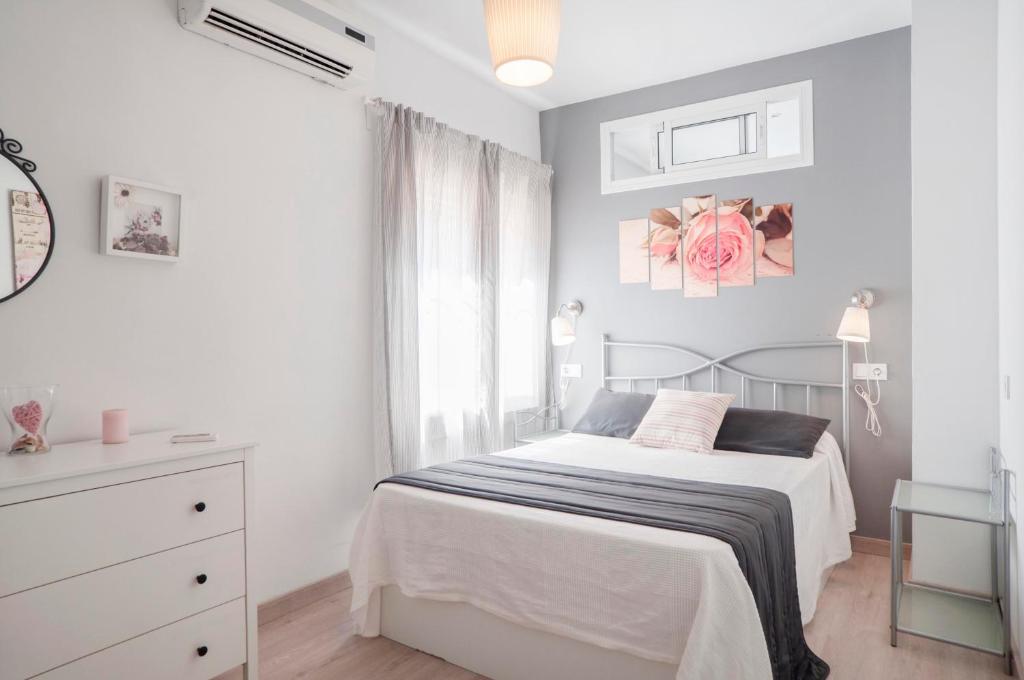 biała sypialnia z łóżkiem i oknem w obiekcie 16 Benal Acogedor y en 1ª linea w mieście Benalmádena