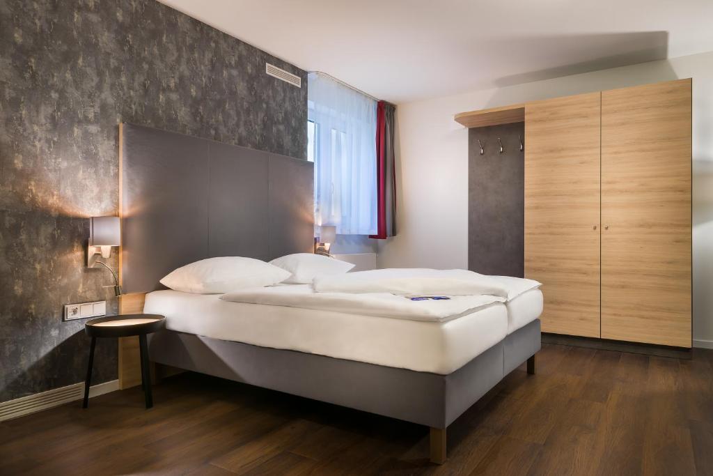 ハンブルクにあるSignature East Hotel Apartmentのベッドルーム1室(白い大型ベッド1台付)