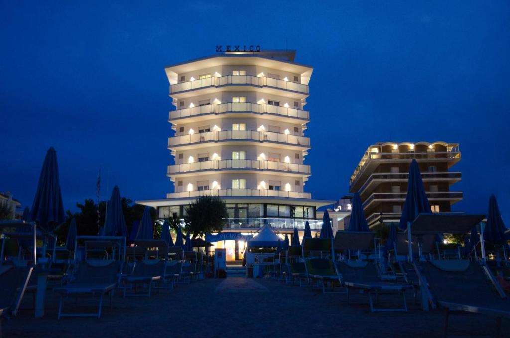 a hotel with chairs in front of a building at night at Hotel Mexico in Bellaria-Igea Marina