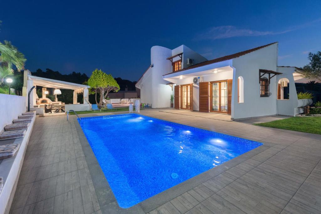 a villa with a swimming pool at night at Una Villa Rhodes in Ixia