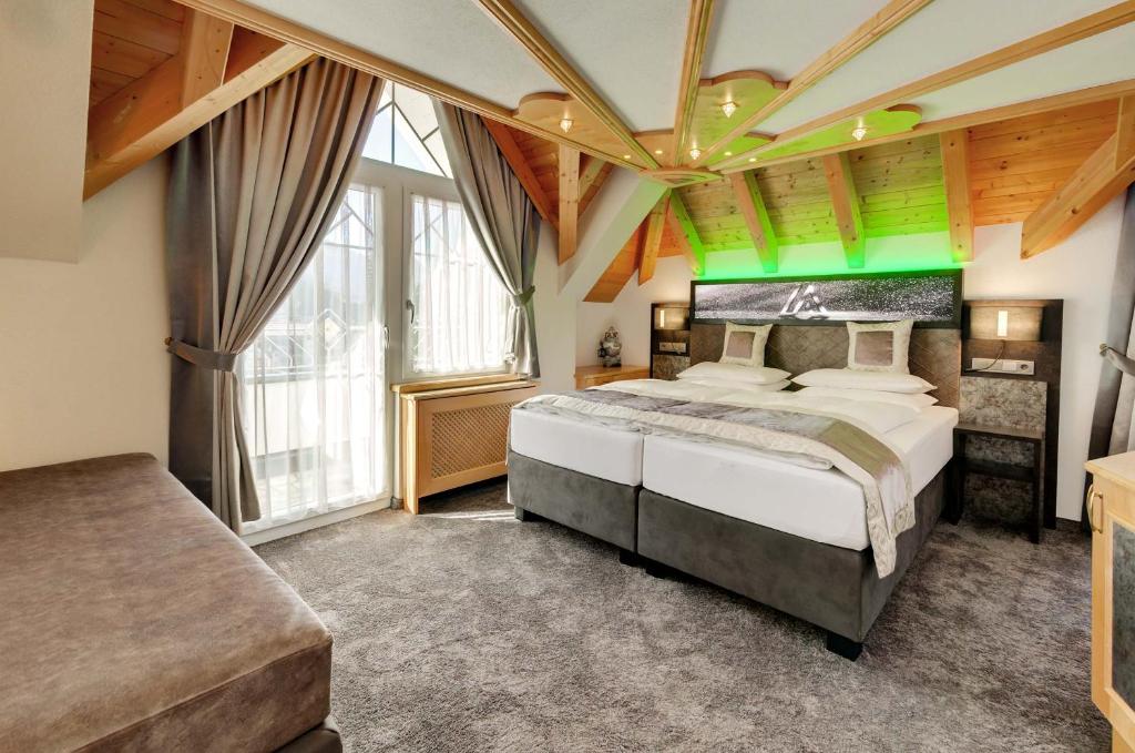a bedroom with a large bed and a large window at Alpinstyle Hotel Ischgl in Ischgl