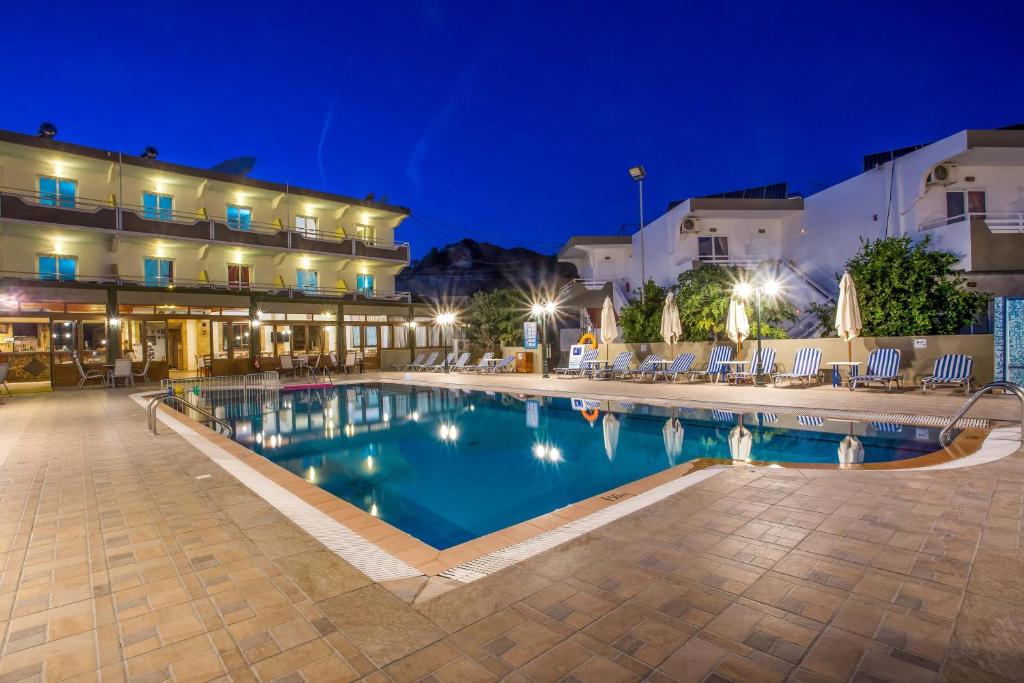 a swimming pool in front of a hotel at night at Georgia Plus - All Inclusive in Afantou