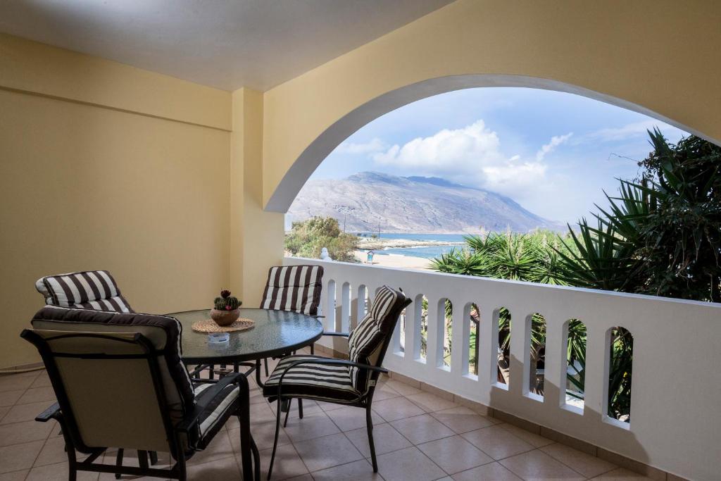 a balcony with a table and chairs and a view of the ocean at Gramvoussa Bay in Kissamos
