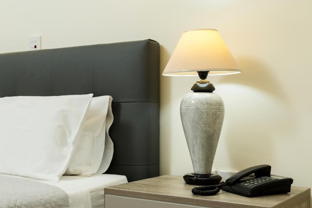 a lamp on a night stand next to a bed at Gramvoussa Bay in Kissamos