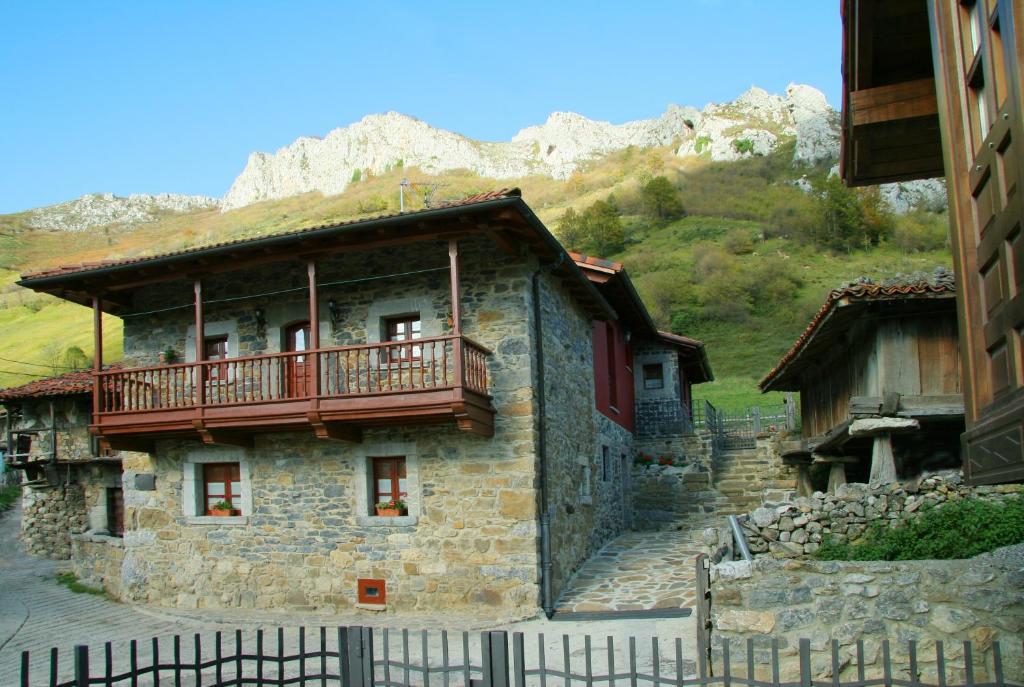 un edificio de piedra con balcón en la parte superior. en Casas Rurales Prieto, en Cortes