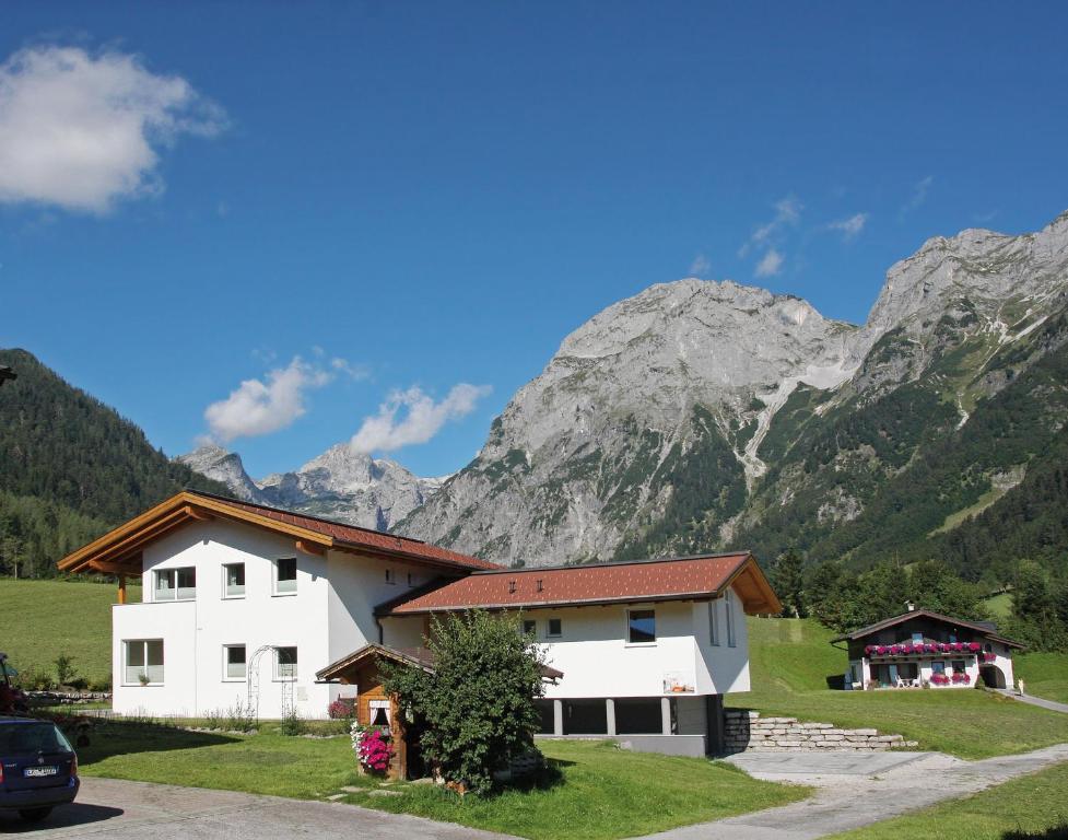 a white house with mountains in the background at Apartment Tennengebirge in Sankt Martin am Tennengebirge