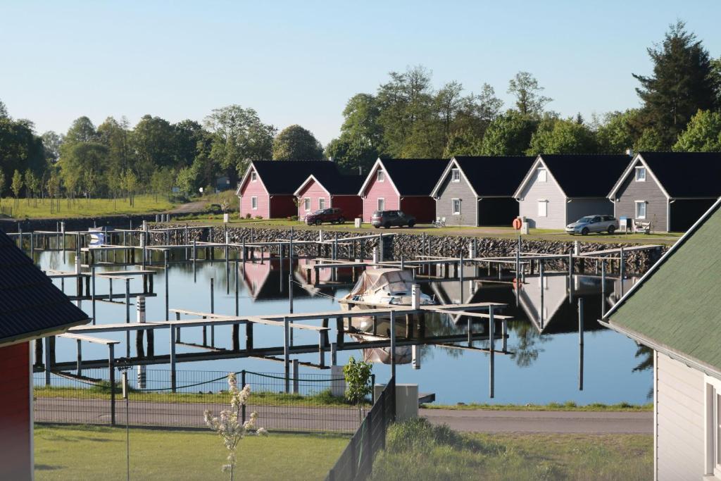 a row of houses on the water with a dock at Skandinavisches-Ferienhaus-2-Reihe-zum-Wasser-fuer-6-Personen in Zerpenschleuse