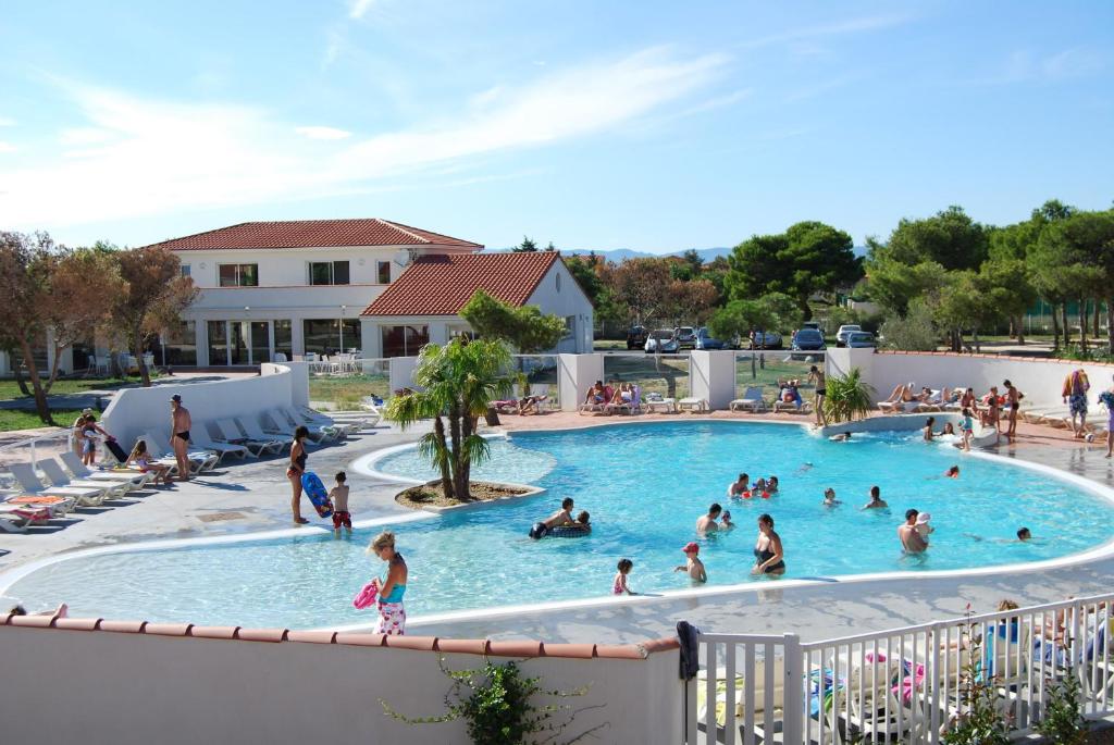 a group of people in a swimming pool at Résidence Lagrange Vacances Le Mas de Torreilles in Torreilles