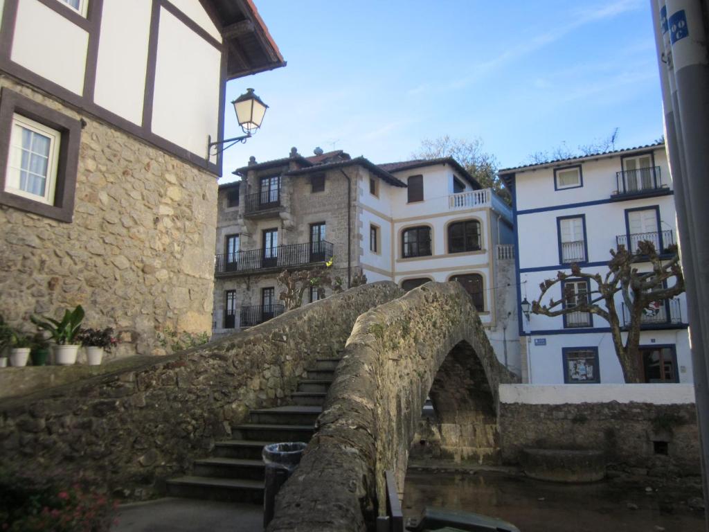 an old stone bridge in a city with buildings at EA playa montaña45'GUGGEMHEIN in Ea