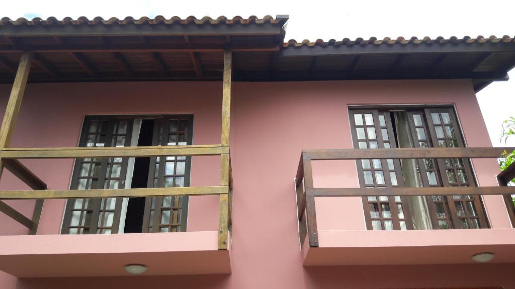 zwei Fenster an der Seite eines rosa Hauses in der Unterkunft Pousada Barra da Lagoa in Florianópolis