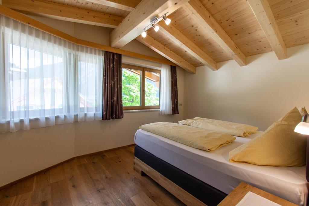 una camera da letto con un letto e una grande finestra di Pension&Appartements Marxenhof a Pertisau