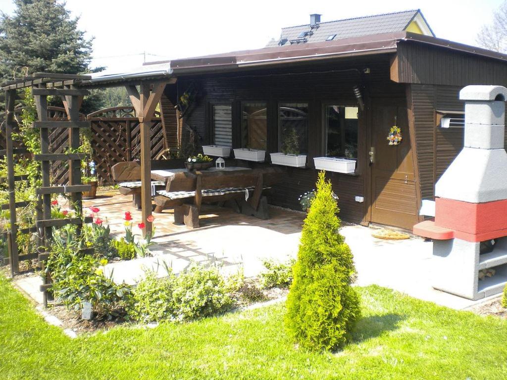 eine Holzhütte mit einem Picknicktisch im Hof in der Unterkunft Ferienbungalow Poppengrün in Poppengrün