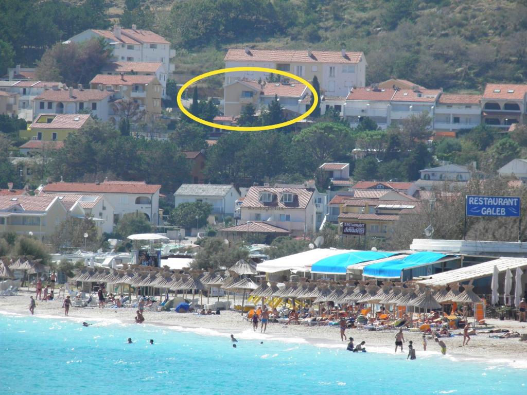 un frisbee amarillo volando sobre una playa llena de gente en Apartments Mikulan Nara, en Baška