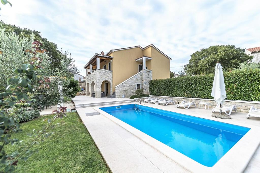 a swimming pool in the backyard of a house at Villa Ladonja with Private Pool and Sauna in Marasi