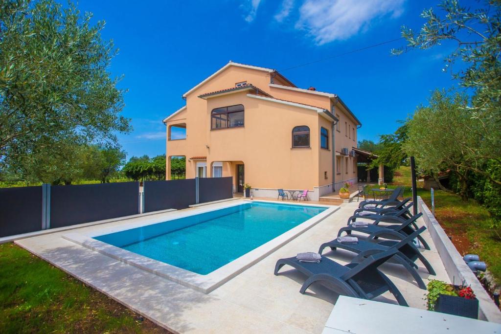 a villa with a swimming pool and a house at Three-Bedroom Apartment Mir with Private Infinity Pool in Vošteni