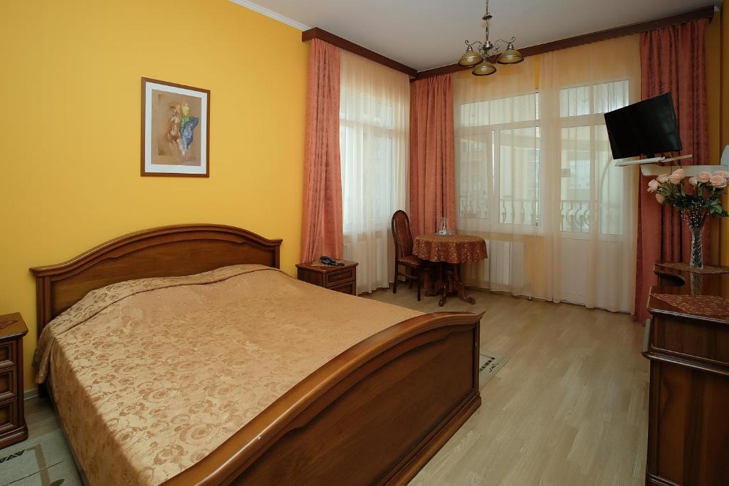 1 dormitorio con 1 cama, TV y mesa en Lira Hotel, en Saratov