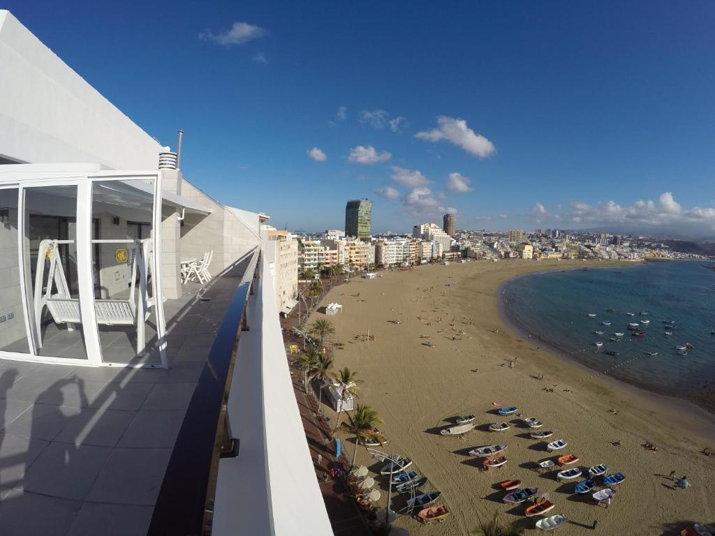 una vista de la playa desde el balcón de un edificio en Apartamentos Juan Pérez- Viviendas Vacacionales, en Las Palmas de Gran Canaria