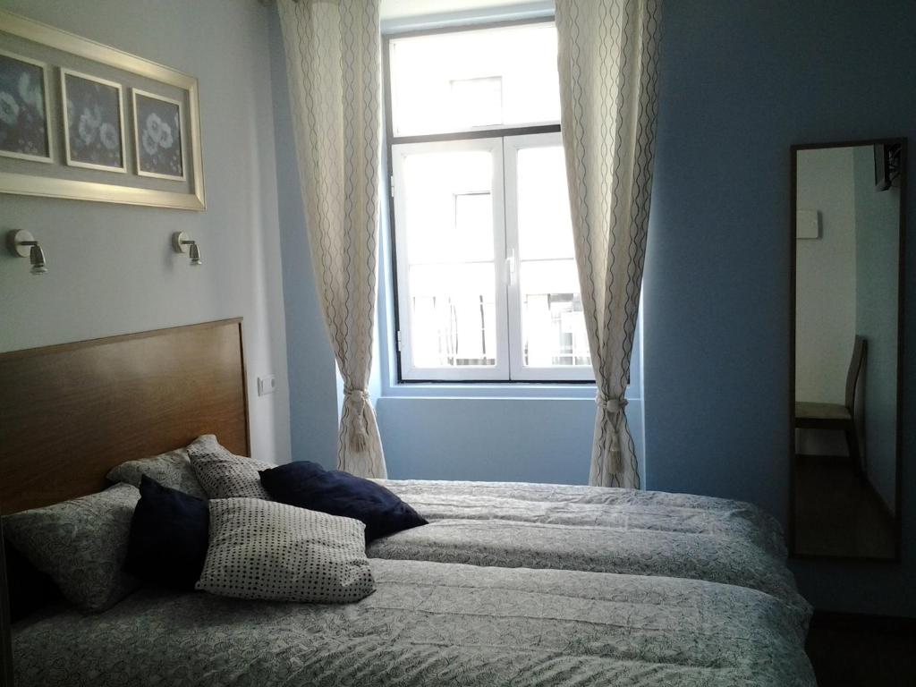1 dormitorio con 1 cama grande y ventana en Baixa GuestHouse, en Lisboa