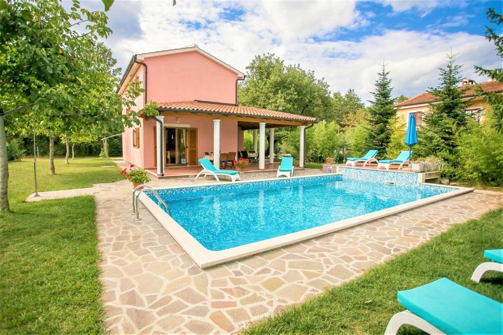 een huis met een zwembad in een tuin bij Pleasant Villa Valmonida with Pool, Sauna, Gym and BBQ in Žminj
