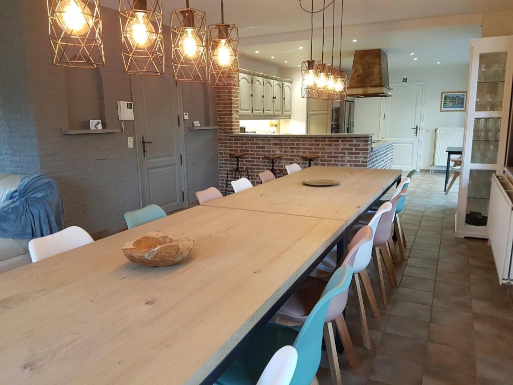 uma cozinha com uma grande mesa de madeira e cadeiras em De Goeferdij vakantiewoning em Geraardsbergen