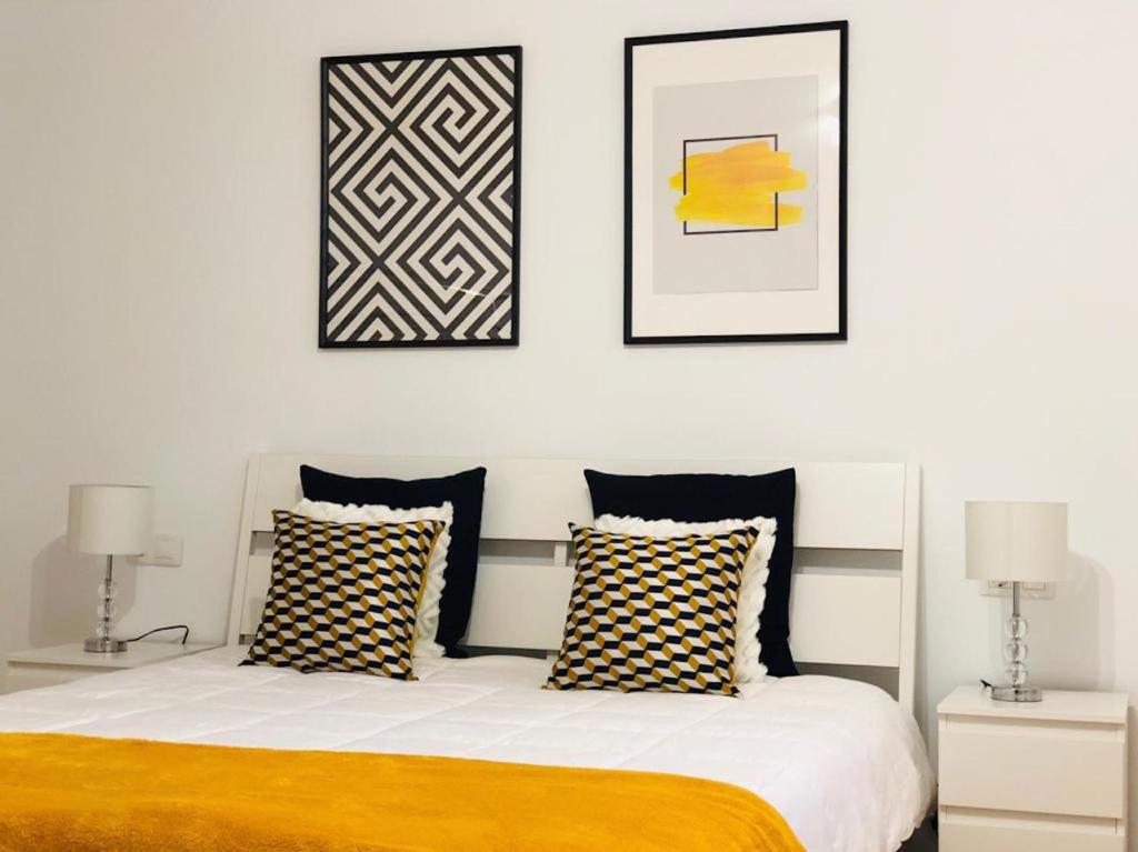 una camera con un letto con due lampade e due immagini di Canaryislandshost l Lovely Lanzarote a Nazaret
