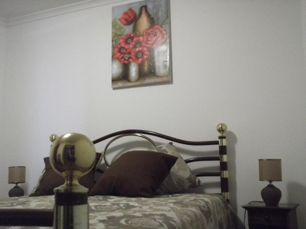a bedroom with a bed and a painting on the wall at Casa da Avó in Castelo de Vide