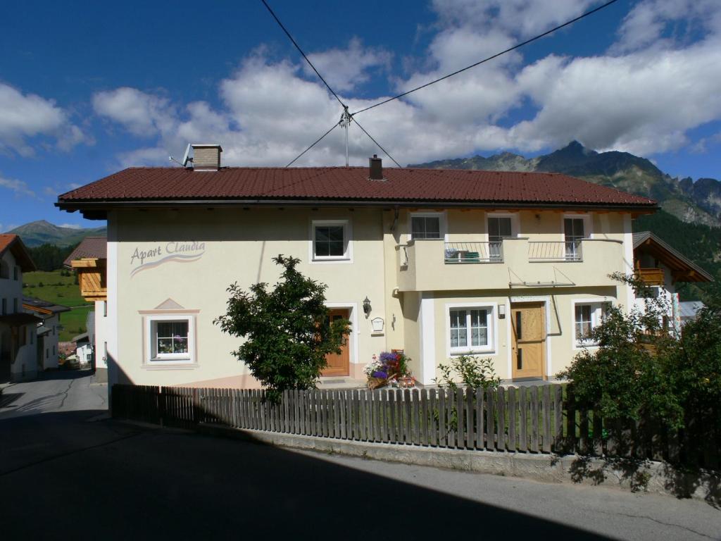 a white house with a fence in front of it at Apart Claudia in Nauders