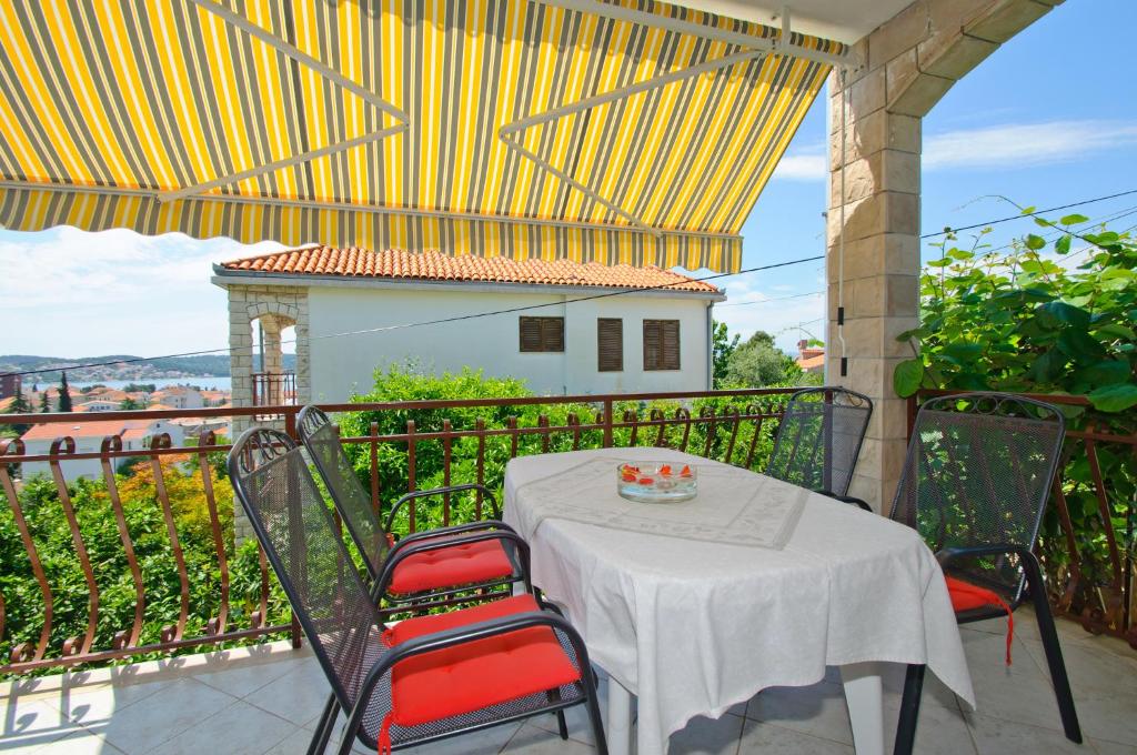 una mesa y sillas en un balcón con vistas en Hella Apartments, en Trogir