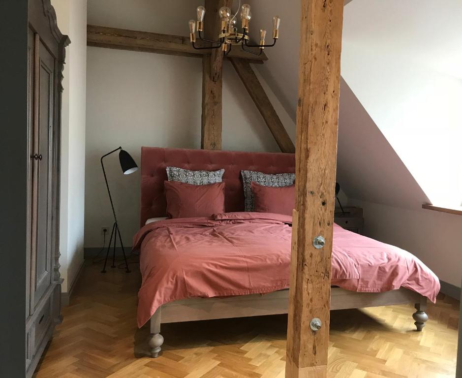 een slaapkamer met een houten bed met roze lakens bij Beautiful apartments - Romantic in Liepāja