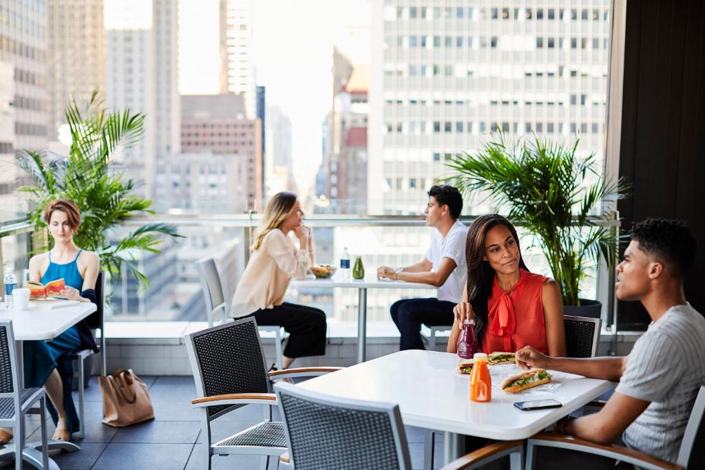 een groep mensen die aan tafels in een restaurant zitten bij Hotel Boutique at Grand Central in New York