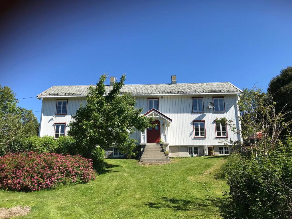 una casa bianca con una porta rossa e un cortile di Rodal Lodge a Valsøybotn