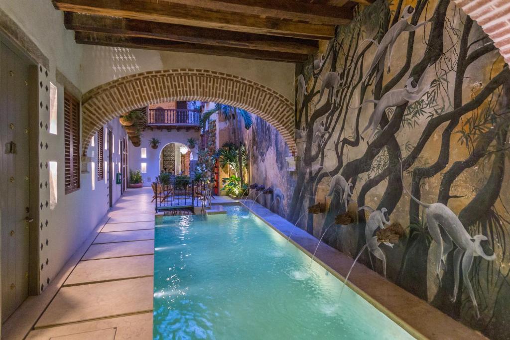 an indoor pool in a building with a mural at Hotel Casa La Factoria by Faranda Boutique, a member of Radisson Individuals in Cartagena de Indias