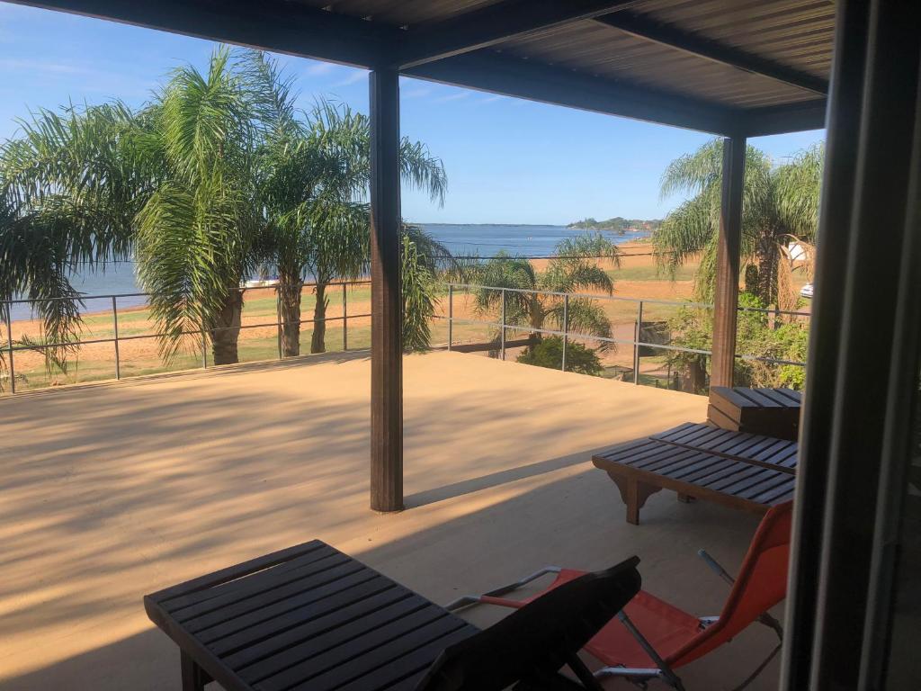 a screened in porch with a table and a bench at TERRAZA al RIO in Paso de la Patria