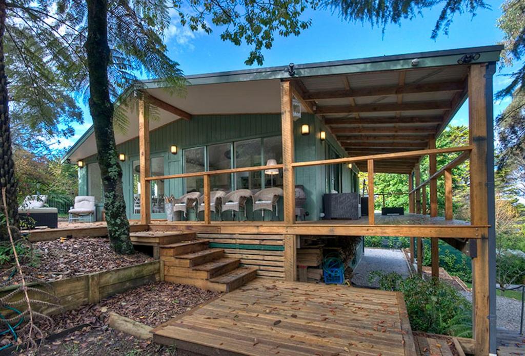 a home with a large wooden deck and a house at Ribbon Gum Lodge in Katoomba