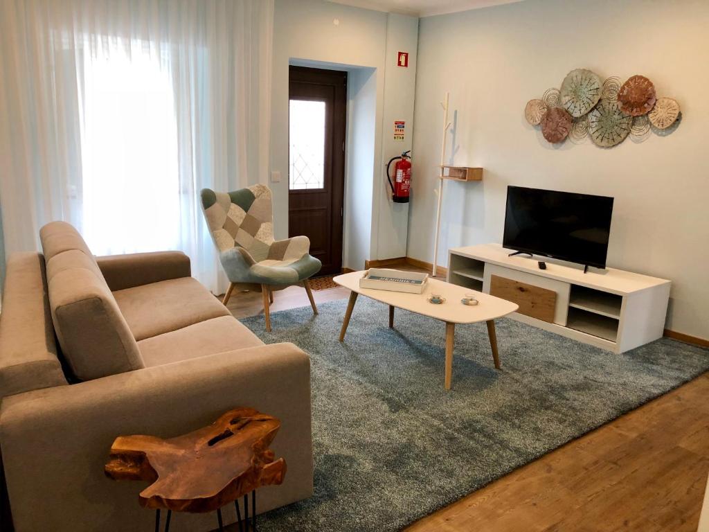 a living room with a couch and a tv at Casa da Miragaia in Angra do Heroísmo