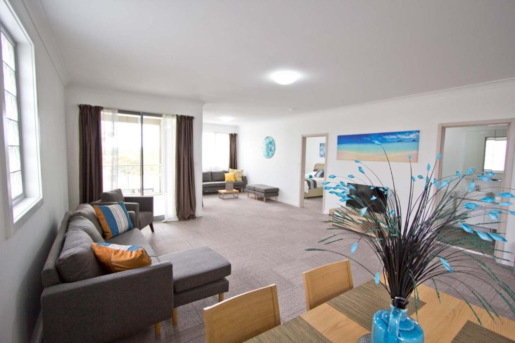 a living room with a couch and a table at Morisset Serviced Apartments in Morisset