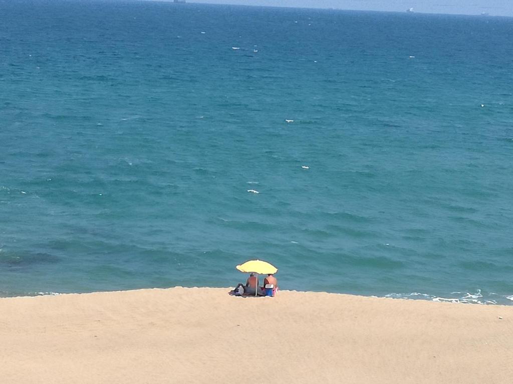 2 personnes assises sous un parasol sur la plage dans l'établissement North Beach Road, à Umdloti