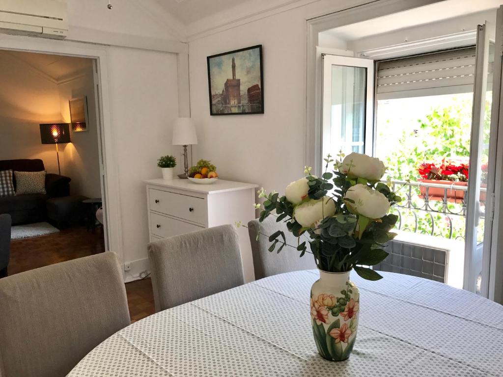 een vaas met bloemen op een tafel in een woonkamer bij Luciano Resident in Lissabon