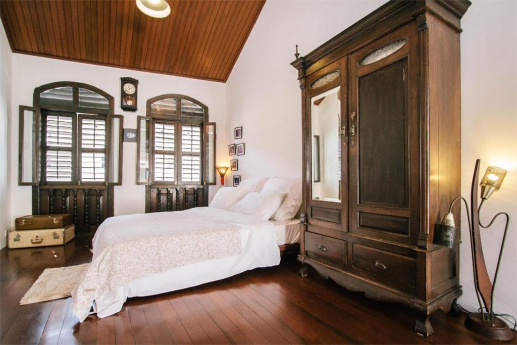 um quarto com uma cama grande e um armário de madeira em Boutique Guest House em George Town