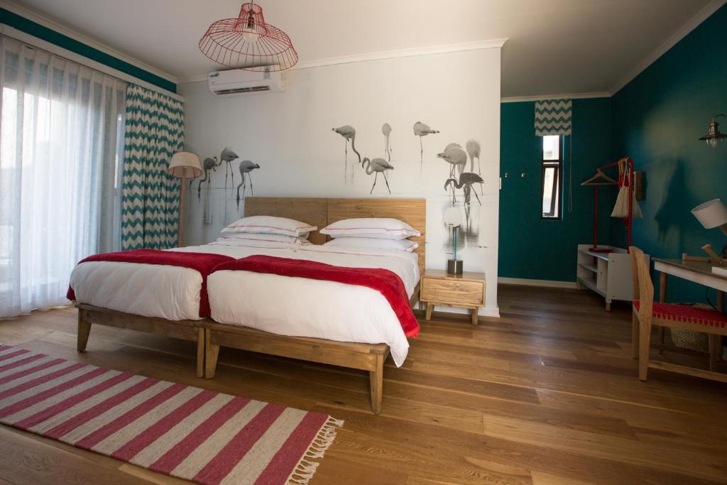a bedroom with a large bed and a desk at The Delight Swakopmund in Swakopmund