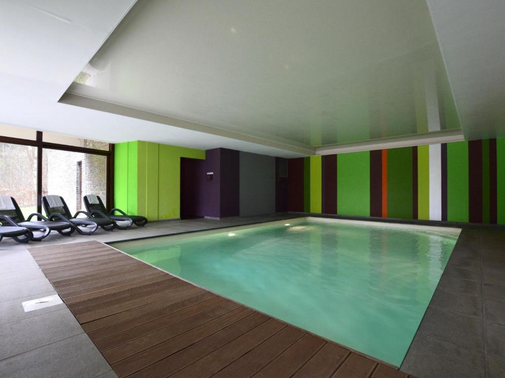 マルメディにあるLuxurious villa in Malmedy with indoor swimming poolの緑とカラフルな壁の客室内のスイミングプール