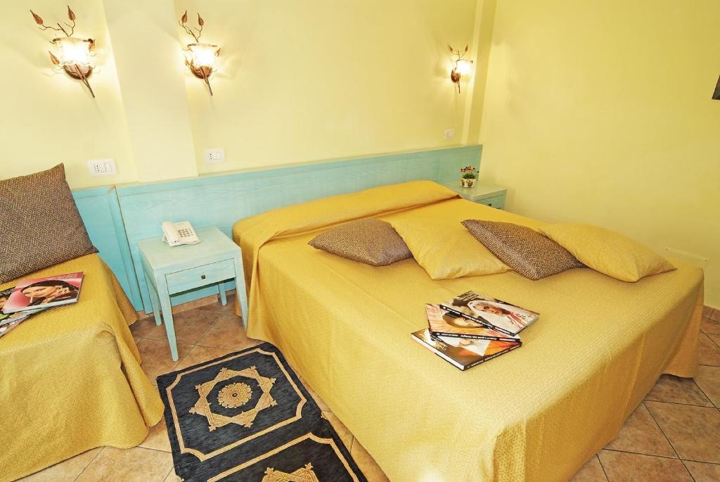 a small bedroom with two beds and a table at Hotel Del Corso in Pula