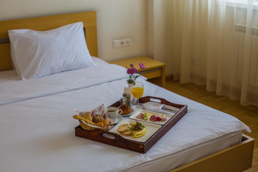 a tray of food on top of a bed at AZIMUT Hotel Siberia in Novosibirsk