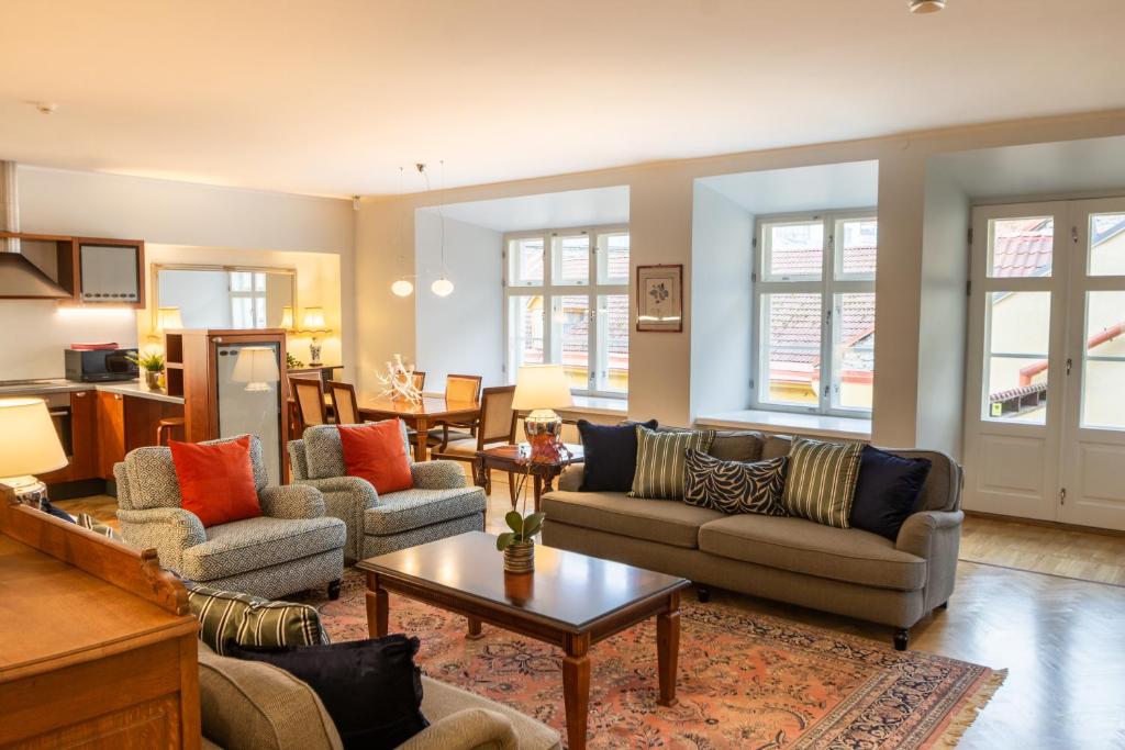 un salon avec des canapés, des tables et des fenêtres dans l'établissement Tallinn City Apartments Luxury 4 bedroom with terrace and sauna, à Tallinn