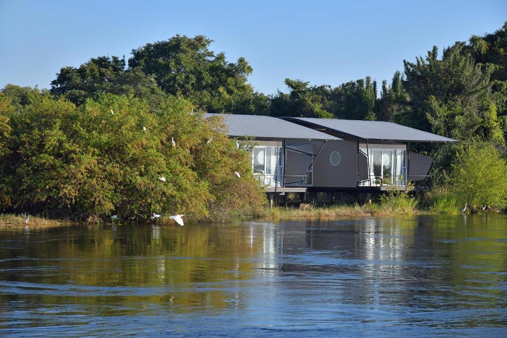 ein Haus am Ufer eines Flusses in der Unterkunft Zambezi Mubala Lodge in Katima Mulilo