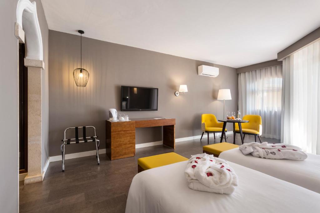 a hotel room with two beds and a tv at AP Oriental Beach - Adults Friendly in Portimão